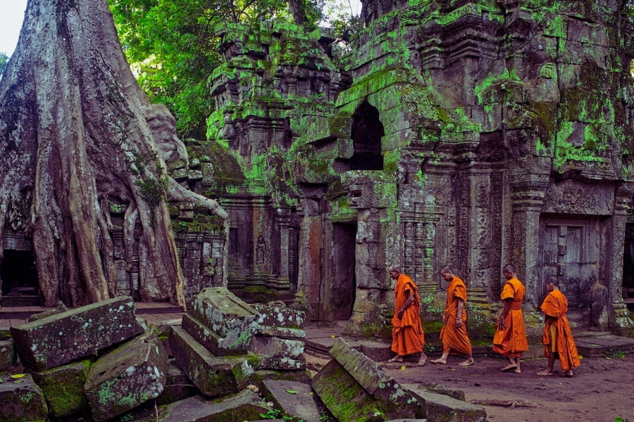 Buddhist monks walking through Ta Prohm temple ruins in Angkor, Cambodia – Auasia Travel
